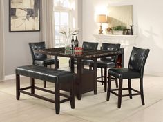 a dining room table and chairs with a fireplace in the background