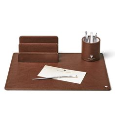 a brown desk set with pens, pencils and pen holder on top of it