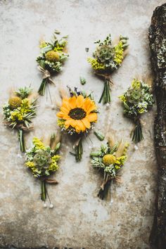 an arrangement of flowers arranged in the shape of a sunflower on a stone surface