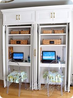 two computer screens sitting on top of a white bookcase