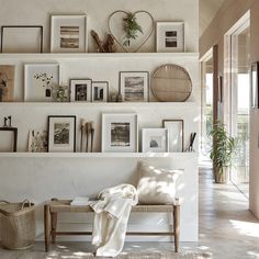 a living room filled with furniture and pictures on the wall