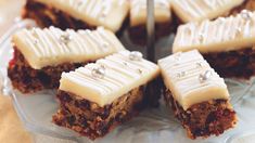 there are several pieces of cake on the plate with white frosting and silver beads