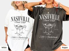 two women wearing matching nashville t - shirts