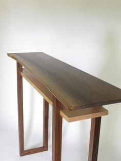 a wooden table sitting on top of a white wall