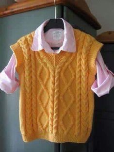 a yellow sweater hanging on a clothes rack with a pink shirt underneath it and a white collar