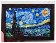 someone is holding up a piece of art that looks like the starry night painting