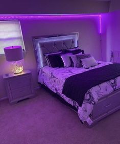 a bedroom with purple lighting and a large bed