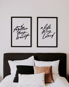 two black and white prints above a bed