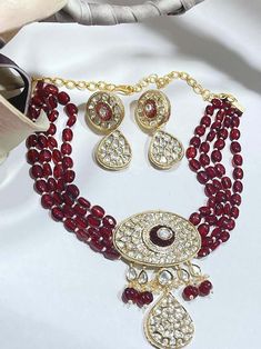 💕 A perfect piece of art with full of radiance, lot of luster and always a keeper in your jewelry trinket. Delicate Polki studded choker necklace beaded together with deep red beads, cluster pearls & melon beads with potta stone on brass base metal, gold finish all over. Matching pair of earrings makes this choker a full set. Perfect Indian Wedding Jewelry. Great for any occasion. Style this with any Ethnic Attire. Drawstring adjustable. ✅ WHAT GOES IN 👉🏻Premium Quality raw materials, high cl Studded Choker, Kundan Choker Set, Necklace Set Indian, Kundan Choker, Jewelry Trinket, Red Beads, Choker Necklace Set, Choker Set, Jewelry Beaded