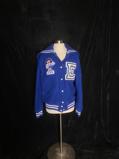 "1990's royal blue letterman jacket with white piping. From East High in Lincoln Nebraska. Has a little cheerleader patch with the name Laura and the letter E with dance on it. Back flap has Apollonaires on it. Has a little stain on the back, shown in photo. Otherwise great vintage condition Women's medium 44\" max bust 26.5\" shoulder to hem 19\" back shoulders" Blue Collegiate Style Varsity Jacket For Sports Events, Blue Collegiate Varsity Jacket For Sports Events, Collegiate Blue Outerwear For Game Day, Collegiate Blue Hooded Varsity Jacket, Blue Collegiate Hooded Varsity Jacket, Blue Hooded Collegiate Varsity Jacket, Retro Cotton Varsity Jacket For School, Collegiate Blue Varsity Jacket For Fall, Retro Blue Hooded Varsity Jacket