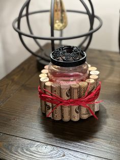 a bottle with some wine in it sitting on a table next to a clock and other items