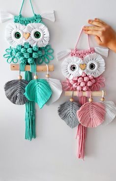 two owls are hanging on the wall with tassels