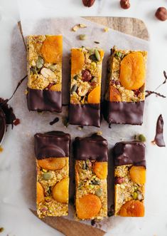 several pieces of fruit and nut bar on a cutting board