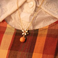 a close up of a person wearing a white shirt and necklace with flowers on it