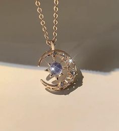 Elevate your style with our enchanting Moon & Star Pendant Necklace, a perfect blend of celestial charm and timeless elegance. This stunning necklace features a crescent moon and star design, meticulously crafted in two exquisite finishes: lustrous gold and shimmering silver. Key Features: - Design: The pendant showcases a delicate crescent moon cradling a radiant star, symbolizing dreams and guidance. The moon is adorned with intricate detailing, and the star is set with a sparkling cubic zirconia stone at its center, mimicking the beauty of a twinkling star in the night sky. - Material: Made with high-quality materials, the pendant is available in both gold-tone and silver-tone finishes, ensuring durability and lasting shine. The central stone is a stunning blue cubic zirconia, adding a Moon And Star Design, Moon Star Pendant, Crescent Moon And Star, Graduation Rings, Unique Pendant Necklace, Silver Key, Star Pendant Necklace, Crescent Moon Necklace, Moon And Star