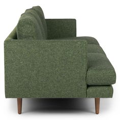 a green couch sitting on top of a white floor next to a wooden leg chair