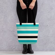 Discover elegance and functionality with our Stylish Horizon Striped Tote Bag. This tote combines bold teal, light blue, black, and white stripes in a minimalist palette, perfect for everyday use or as a statement piece. Crafted from 100% spun polyester fabric, this tote is not only durable but also lightweight. It boasts a spacious size of 15″ × 15″ (38.1 × 38.1 cm) with a capacity of 2.6 US gallons (10 liters), ensuring ample room for all your essentials. Whether you're heading to the beach, grocery shopping, or running errands, this tote can comfortably carry up to 44lbs (20 kg). Designed for practicality, it features dual handles made from 100% natural cotton bull denim, offering a comfortable grip with a handle length of 11.8″ (30 cm) and a width of 1″ (2.5 cm). Key Features: - Bold t Modern Striped Tote Bag, Modern Turquoise Bag For Everyday Use, Minimalist Palette, Striped Tote Bag, Teal Light, Trendy Tote, Black Tote Bag, Stripes Design, Teal Blue