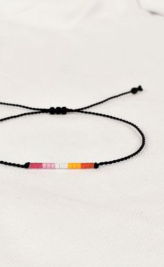 Lesbian bracelet string adjustable, Subtle lesbian jewelry, Beaded LGBTQA bracelet, Lesbian accessories, gift for lesbian best friend Adjustable Rainbow Friendship Bracelets With Letter Beads, Rainbow Friendship Bracelets With Sliding Knot, Rainbow Jewelry With Sliding Knot For Gift, Rainbow Resizable Beaded Bracelets For Friendship, Resizable Rainbow Beaded Friendship Bracelets, Resizable Rainbow Friendship Bracelets, Rainbow Sliding Knot Bracelet As Gift, Rainbow Adjustable Cord Friendship Bracelet As Gift, Adjustable Round Beads Friendship Bracelet For Best Friend