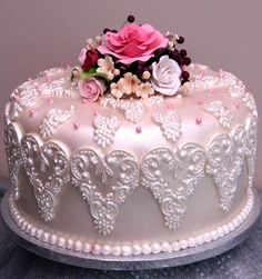 there is a white cake with pink flowers on it