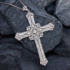 This breathtaking platinum cross shaped pendant features a pierced design with milgrain details and is centered with a round old European cut diamond, weighing 0.28 carats, in a full bezel setting. The center is accented with a total of eighty-eight (88) bead set round cut diamonds. The pendant is topped by a matching bail, bead set with three (3) round single cut diamonds. The pendant measures 71.5mm long, by 46.7mm wide and 4.7mm thick on an 18-inch long, fourteen karat white gold cable link chain, finished with a lobster clasp. Fancy Cross, Antique Engagement Rings Sapphire, Estate Jewelry Rings, White Gold Chains, Bead Set, Antique Engagement Rings, European Cut Diamonds, Cross Pendant Necklace, Engagement Rings Sapphire