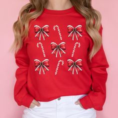 This Santa Bow Candy Cane Aesthetic Christmas Sweatshirt is perfect for cozy winter days, adding a festive and fun holiday style to your wardrobe. Great as a gift for women, this cute pullover captures the joyful spirit of the season with a charming aesthetic. 𝐃𝐄𝐓𝐀𝐈𝐋𝐒 Gildan 18000 Sweatshirt ❄️ 50% cotton, 50% polyester ❄️ Medium-heavy fabric (8.0 oz/yd² (271.25 g/m²) ❄️ Loose fit ❄️ Sewn-in label ❄️ Runs true to size Gildan 2400 Long Sleeve Tee ❄️ 100% cotton (fiber content may vary for different colors) ❄️ Medium fabric (6.0 oz/yd² (203 g/m ❄️ Classic fit ❄️ Sewn-in label ❄️ Runs smaller than usual for men; very loose fit for women Gildan 64000 Short Sleeve T-Shirt ❄️ 100% cotton (fiber content may vary for different colors) ❄️ Lightweight fabric (4.5 oz/yd² (153 g/m ❄️ Classic fi Festive Long Sleeve Fall Sweatshirt, Cozy Long Sleeve Christmas Tops, Cute Winter Sweater As A Gift, Casual Festive Sweatshirt For Fall, Holiday Cotton Sweater With Long Sleeves, Casual Fall Festive Sweatshirt, Holiday Long Sleeve Cotton Sweater, Long Sleeve Cotton Sweater For Holiday, Cozy Long Sleeve Holiday Tops