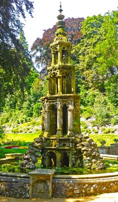 an old water fountain in the middle of a park