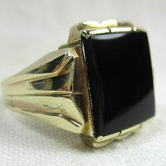 "I offer for your consideration this Men's antique, estate, genuine Art Deco signet style ring with a yellow gold setting and a rectangular Onyx gemstone.  It is size 12.25 and it can be sized by your jeweler, if needed. It is made from 14K yellow gold. Ring face is 5/8 of an inch both high and across.  It weighs 10.1 grams and it has SEVEN hallmarks.  I believe it was created in England. I AM NOT A JEWELER!  I am an admirer and collector of fine antique and vintage jewelry purchased at estate sales and antique sales across the country. FREE SHIPPING and insurance will be offered with this item, as well as excellent packaging. I provide numerous close-up photos taken with a high quality camera so potential buyers can spot possible defects in the stones or settings.  Of course, if I notice Gold Signet Ring, Yellow Gold Setting, Onyx Gemstone, Men's Ring, Estate Sales, Gold Set, Signet Ring, Gold Style, Vintage Men