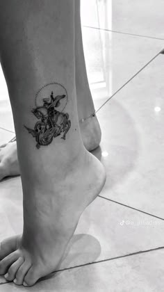 a woman's foot with a tattoo design on the side of her leg and an anchor