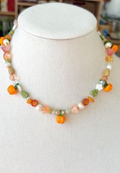 Embrace the beauty of fall with our stunning Pumpkin Patch Beaded Necklace! This charming piece is a perfect blend of autumn hues and festive cheer, making it an ideal accessory for the season. Handcrafted with care, each necklace features a delightful array of beads in rich oranges, warm browns, and deep greens, reminiscent of a cozy pumpkin patch. The necklace is adorned with intricately designed pumpkin charms that capture the essence of the harvest season. Whether you're celebrating Halloween, Thanksgiving, or simply want to add a touch of fall to your wardrobe, this necklace is the perfect choice. It's versatile enough to pair with casual outfits or to add a festive flair to your evening wear. Key Features: *Handmade: Every necklace is carefully crafted by hand, ensuring a unique and Autumn Beaded Necklace, Handmade Bohemian Halloween Necklace, Handmade Beaded Necklaces For Halloween Gift, Handmade Multicolor Jewelry For Fall, Handmade Bohemian Jewelry For Fall, Handmade Adjustable Jewelry For Fall, Adjustable Handmade Jewelry For Fall, Fall Necklaces Beaded, Pumpkin Beads Necklace