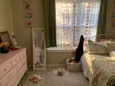 a bedroom with a bed, dresser and window in the corner that has curtains on it