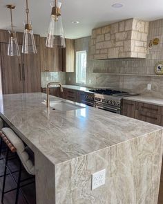 a kitchen with marble counter tops and stainless steel appliances