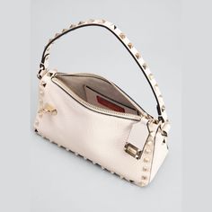 Valentino Garavani shoulder bag in calf leather with Rockstud trim. Platinum-finish studs and hardware. Flat top handle, 5" drop Detachable, adjustable shoulder strap, 50cm/ 19.7" drop. Can be worn on the shoulder, across the body or as a handbag. Zip top and flip-lock tab closures. Interior, one slip pocket, one card slot. 5.1"H x 7.4"W x 2.8"D Item weighs approx. 0.90 lb. Made in Italy. Designer Baguette Bag For Errands, Designer Top Handle Baguette Bag For Errands, Designer Handheld Baguette Bag With Top Carry Handle, Designer Baguette Bag With Detachable Strap For Errands, Designer Crossbody Baguette Bag, Luxury Baguette Shoulder Bag With Top Handle, Designer Handheld Bags With Gold-tone Hardware, Luxury Shoulder Baguette Bag With Top Carry Handle, Luxury Baguette Bag With Removable Top Handle Pouch