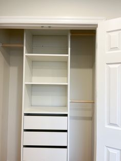 an empty closet with white shelves and drawers