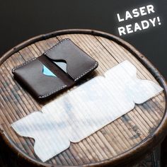 a leather wallet sitting on top of a wooden table next to another piece of luggage