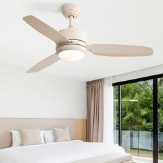 a bedroom with a bed, ceiling fan and sliding glass doors leading to the outside