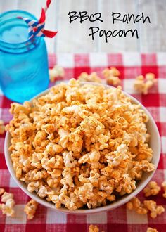 a bowl filled with popcorn sitting on top of a checkered table cloth