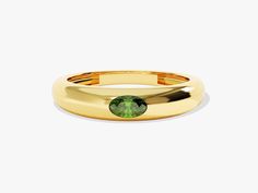 a gold ring with a green stone in the center and a thin band around it