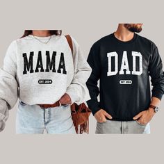 FREE SHIPPING IN THE US! No order minimum!  Mom and Dad Sweatshirt, Mama Dad Sweatshirt, Mom Dad Est Shirt, Mom Dad Est 2024, Mama Est 2024, Dad Est 2024, Dad Sweatshirt ♥ The CREWNECK * This is a Gildan 18000 crewneck sweatshirt. * Detailed sizing information can be found in the size chart in the photos. * Printed in the USA. ♥ CARE ＊Machine wash cold, inside-out, gentle cycle ＊Wash with mild detergent and similar colors ＊Tumble dry low or hang-dry ＊Do not bleach or fabric softeners ＊Do not iron directly onto the design ＊Do not dry clean ♥ PRODUCTION & SHIPPING ＊Each sweatshirt is made to order. ＊Production time : 2-7 business days (Excluding weekends, holidays) ＊US Shipping time : 3-6 business days ＊Most US customers received the order within 5-10 days of the order date. ＊If you have a d White Long Sleeve T-shirt For Father's Day, Casual Winter Top With Custom Print, Relaxed Fit Long Sleeve Tops With Lettering, Long Sleeve Tops With Custom Print For Winter, Family Matching Crew Neck Sweatshirt For Father's Day, Casual Crew Neck Tops For Father's Day, Custom Print Long Sleeve Fan Apparel T-shirt, Long Sleeve Custom Print Fan Apparel T-shirt, Long Sleeve Fan Apparel T-shirt With Custom Print