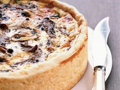 a close up of a pie on a plate with a knife and fork next to it