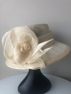 Truly elegant customized handmade high quality 3 layered cream sinamay hat. It may be fitted with a black headband which is easy to hide in your hair if you desired. It is incredibly flattering and easy to wear, strong, light, and comfortable. The hat is ideal to wear to the Kentucky Derby, Royal ascot, any horse racing venue, garden parties, social occasion, easter, weddings including as an accent piece for bridesmaid and mother of bride/groom, church wear, and special events. We make a range o Elegant Handmade Flat Brim Straw Hat, Elegant Handmade Fedora With Curved Brim, Elegant Handmade Fedora With Short Brim, Handmade Elegant Fedora With Curved Brim, Elegant Handmade Short Brim Fedora, Handmade Elegant Fedora For Kentucky Derby, Elegant Handmade Fedora Straw Hat, Elegant Handmade Adjustable Fedora, Elegant Handmade Fedora Sun Hat