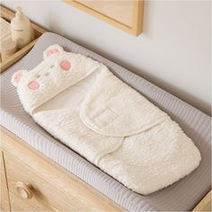 a baby's sleeping bag with a cat design on the front and back, sitting on top of a bed