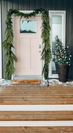 the front door is decorated with greenery for christmas