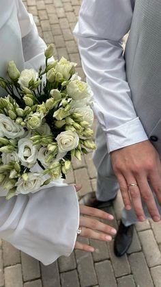 a close up of a person wearing a suit and tie holding a bouquet of flowers