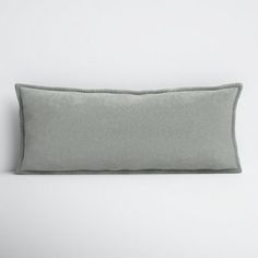 a gray pillow sitting on top of a white wall