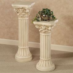 two white pedestals sitting next to each other in a room with a plant on top