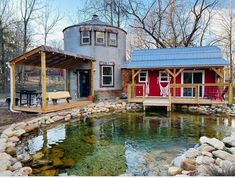 a house with a pond in front of it and a covered porch on the other side