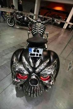 a motorcycle with a skull on the back and red eyes is parked in a parking garage