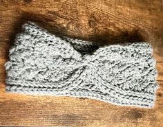 a crocheted headband with a knot on it sitting on a wooden surface