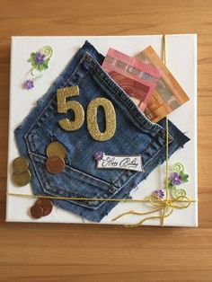 a 50th birthday card made out of old jeans and some gold coins on the bottom