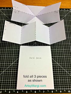 cut out pieces of paper on top of a cutting mat to make an origami box